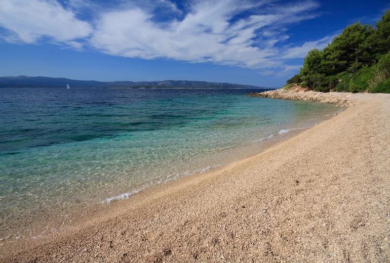 Croatian island anchorage with calm clear water and small village above