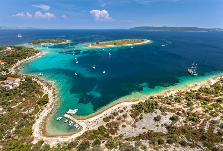Croatian island bay with anchored yachts in clear water